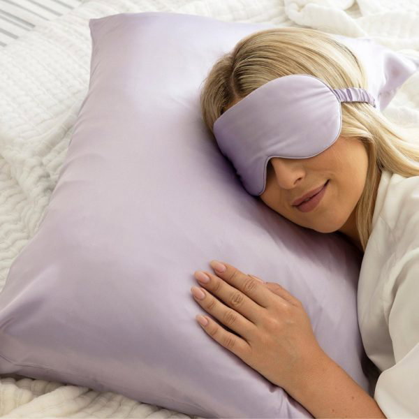 lunalux lilac silk pillowcase with lady sleeping on it with an eye mask on