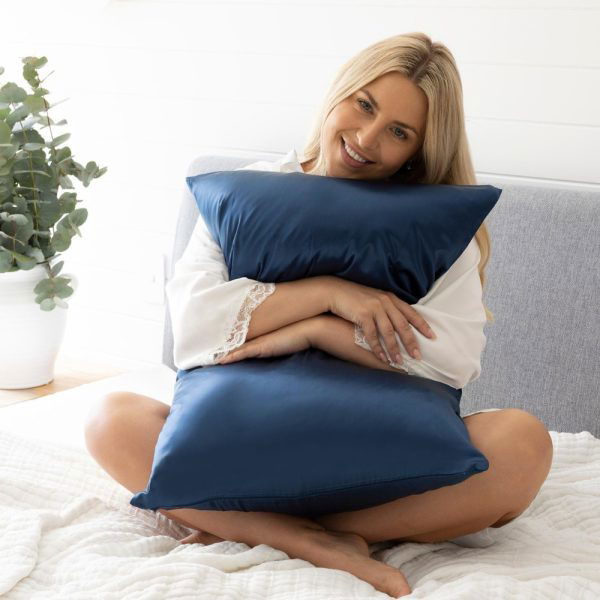 girl holding silk pillowcase in midnight blue
