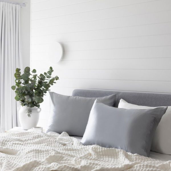 lunalux silver silk pillows on bed in lifestyle shot