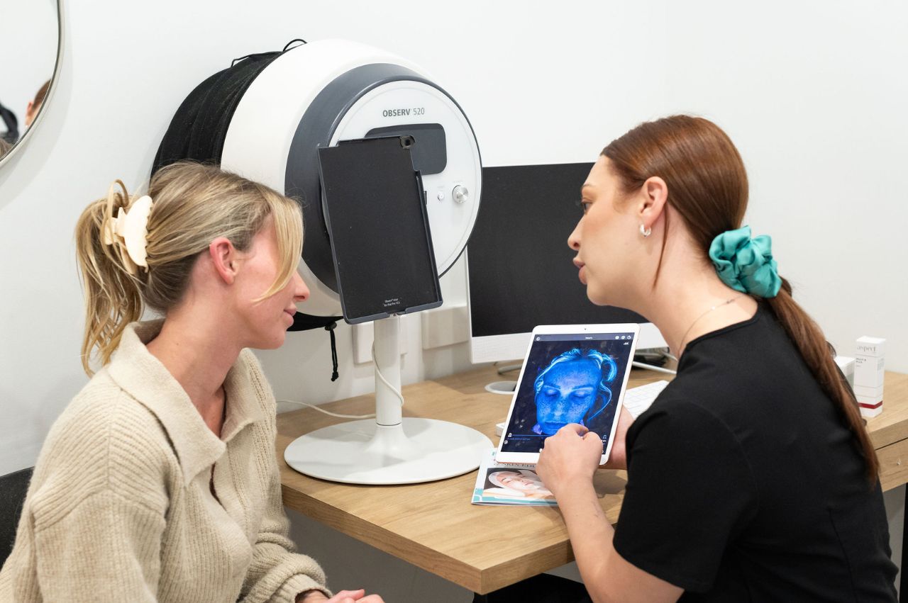 Dermak therapist conducting a skin consultation with woman patient